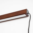 Wood disc wall light mounted on a pale plaster wall