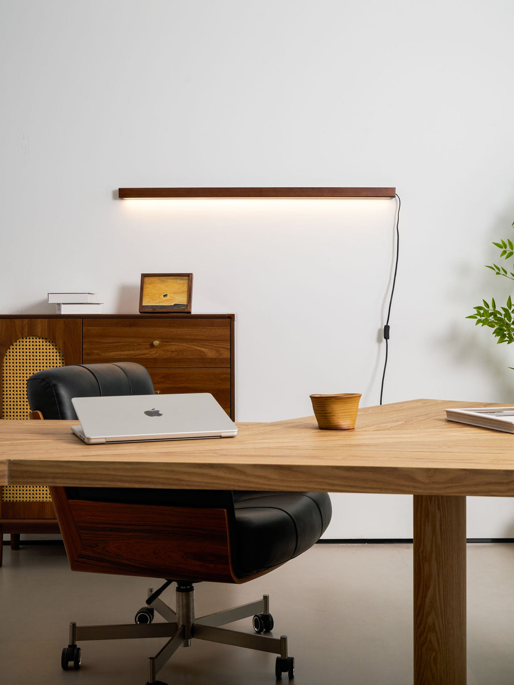 Pine wood disc light glowing warmly above a console