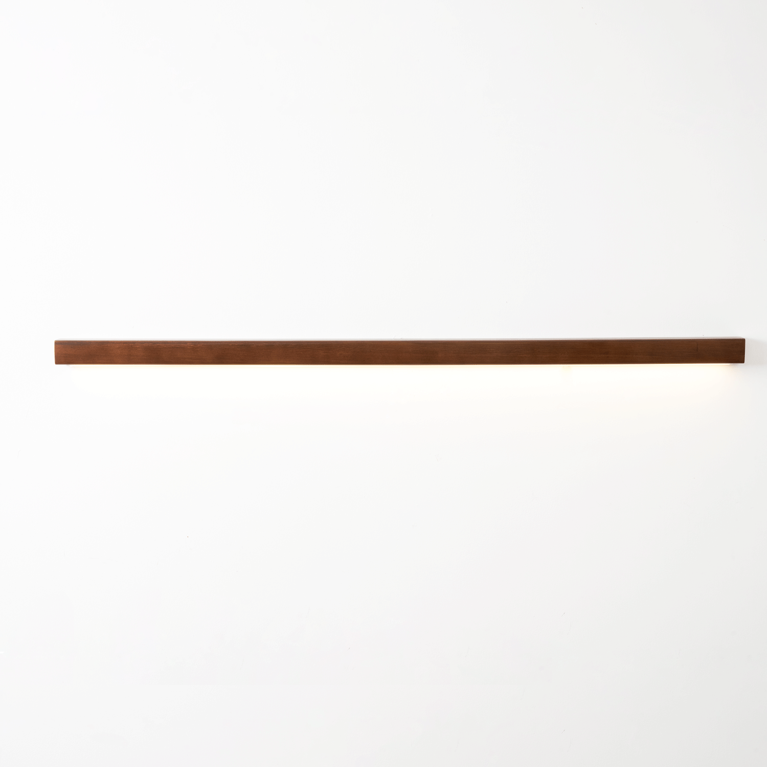 Slim wooden wall light with frosted shade glowing warmly