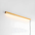 Slim wood wall light mounted flush against a plain wall