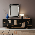 A black marble Clérachic sphere lamp lit on a dark sideboard beneath a mirror, next to a cobalt blue vase.