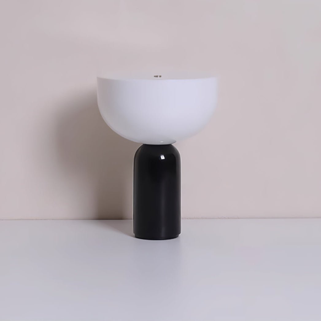 The black marble base of this Clérachic sphere table lamp, shown with its dome shade on a beige background.