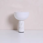 The white marble base and dome shade of this Clérachic table lamp, photographed against a warm beige backdrop.