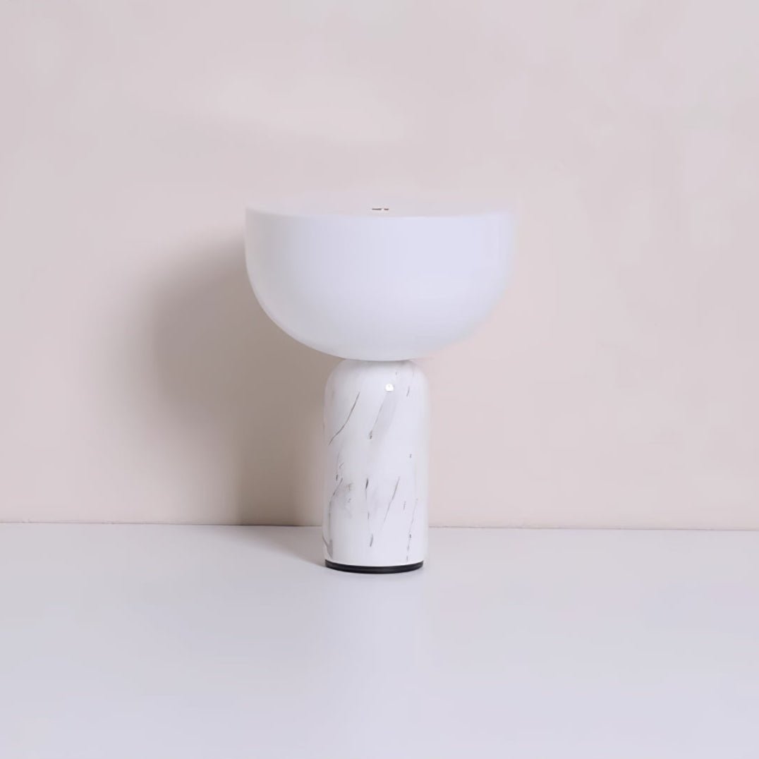 The white marble base and dome shade of this Clérachic table lamp, photographed against a warm beige backdrop.