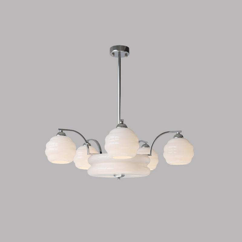 Art Deco chandelier with multiple glass shade heads lit warmly