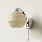 Glass shade wall lamp casting a soft golden glow indoors