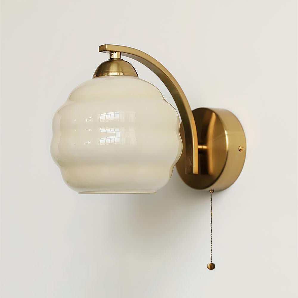 Vintage wall lamp glowing warmly beside a bedside table