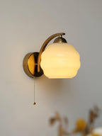 Art Deco wall sconce with warm filament bulb glowing softly