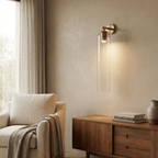 Cylindrical glass wall light with metal base, studio product shot