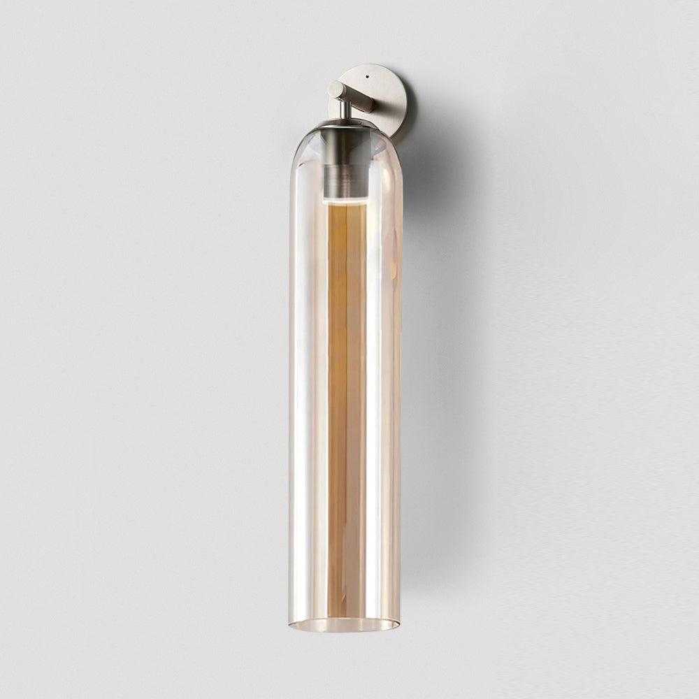 Cylindrical glass sconce casting soft light up the wall