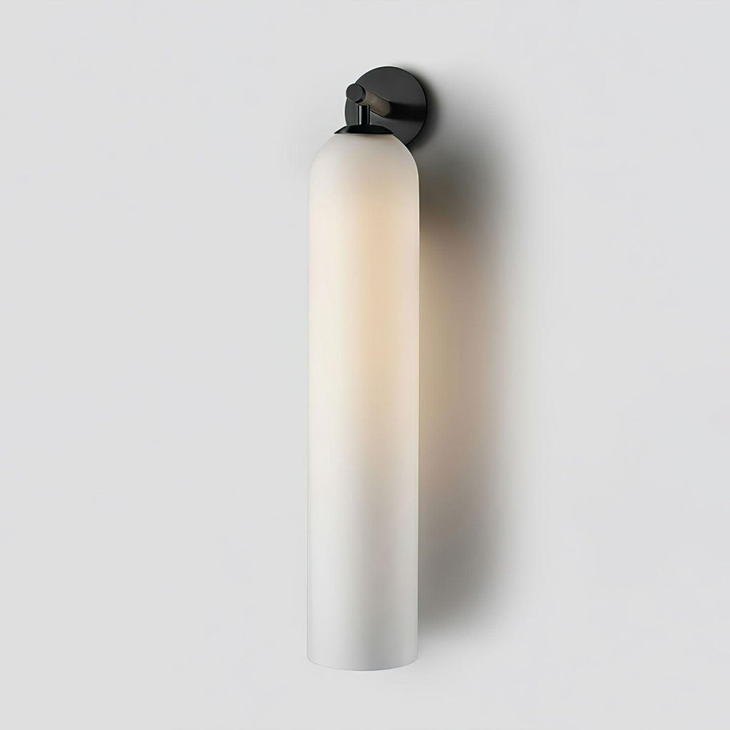 Art glass wall sconce glowing beside a quiet reading corner