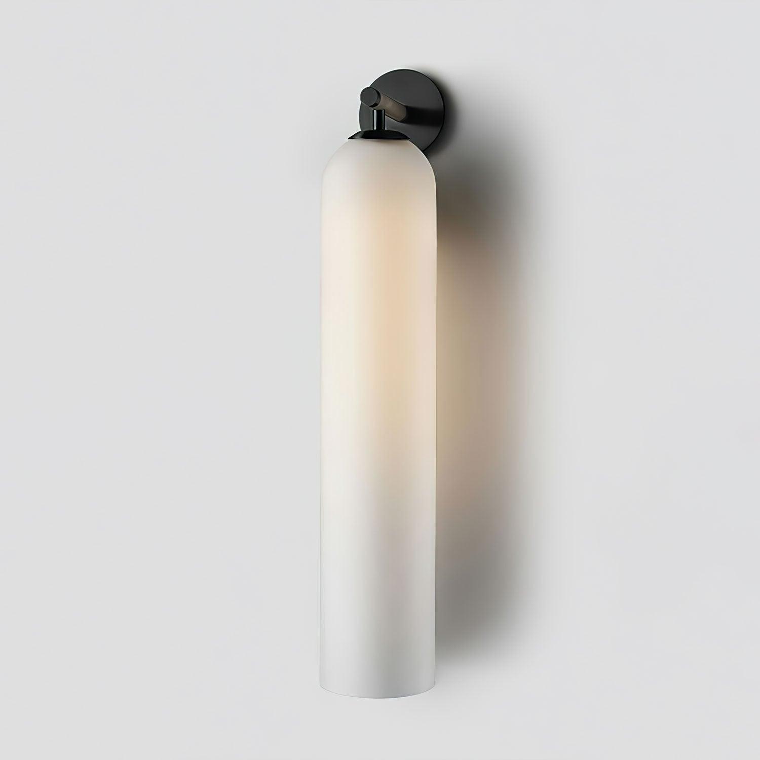 Art glass wall sconce glowing beside a quiet reading corner