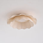 Pleated wave fabric ceiling light glowing in a living area