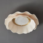 Pleated wave fabric ceiling light glowing warmly indoors
