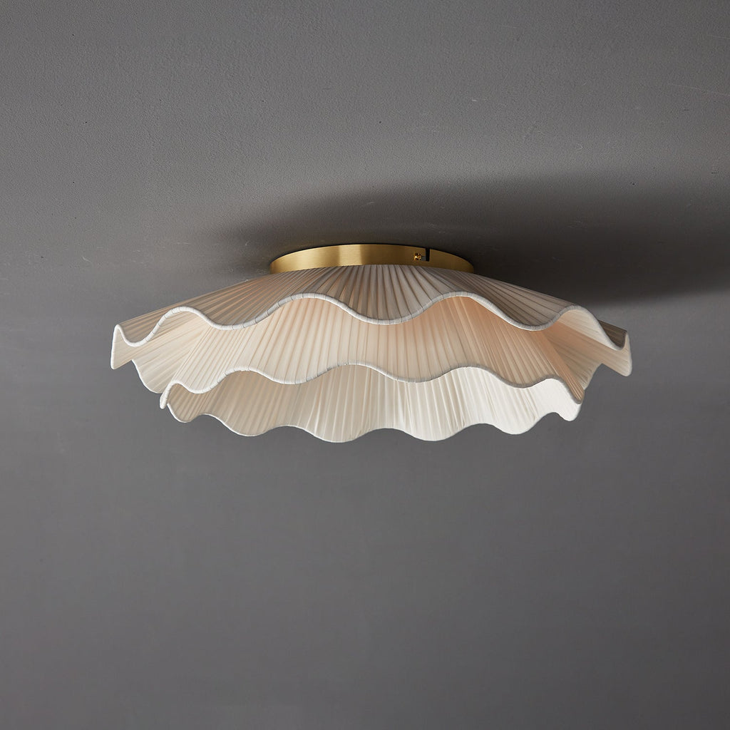 Pleated wave fabric ceiling light shown from below lit