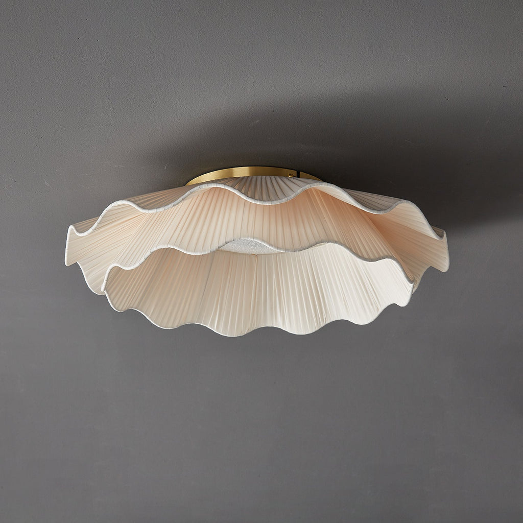 Pleated wave fabric ceiling light against a neutral ceiling