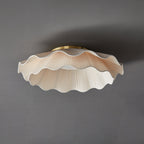 Pleated wave fabric ceiling light against a neutral ceiling