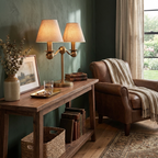 In a sage-green room, this brushed brass Clérachic table lamp lights a console table beside a leather armchair and throw.