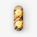 Clérachic marble wall light with two opal glass globes lit warm, shown alone against a plain white background.