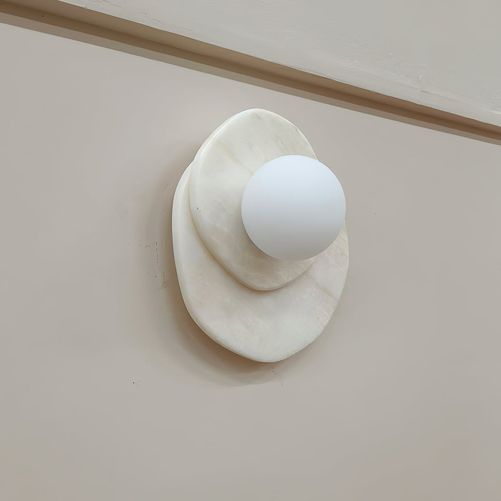 A side view of the Clérachic wall light shows how far its stone discs and glass globe project from the wall surface.