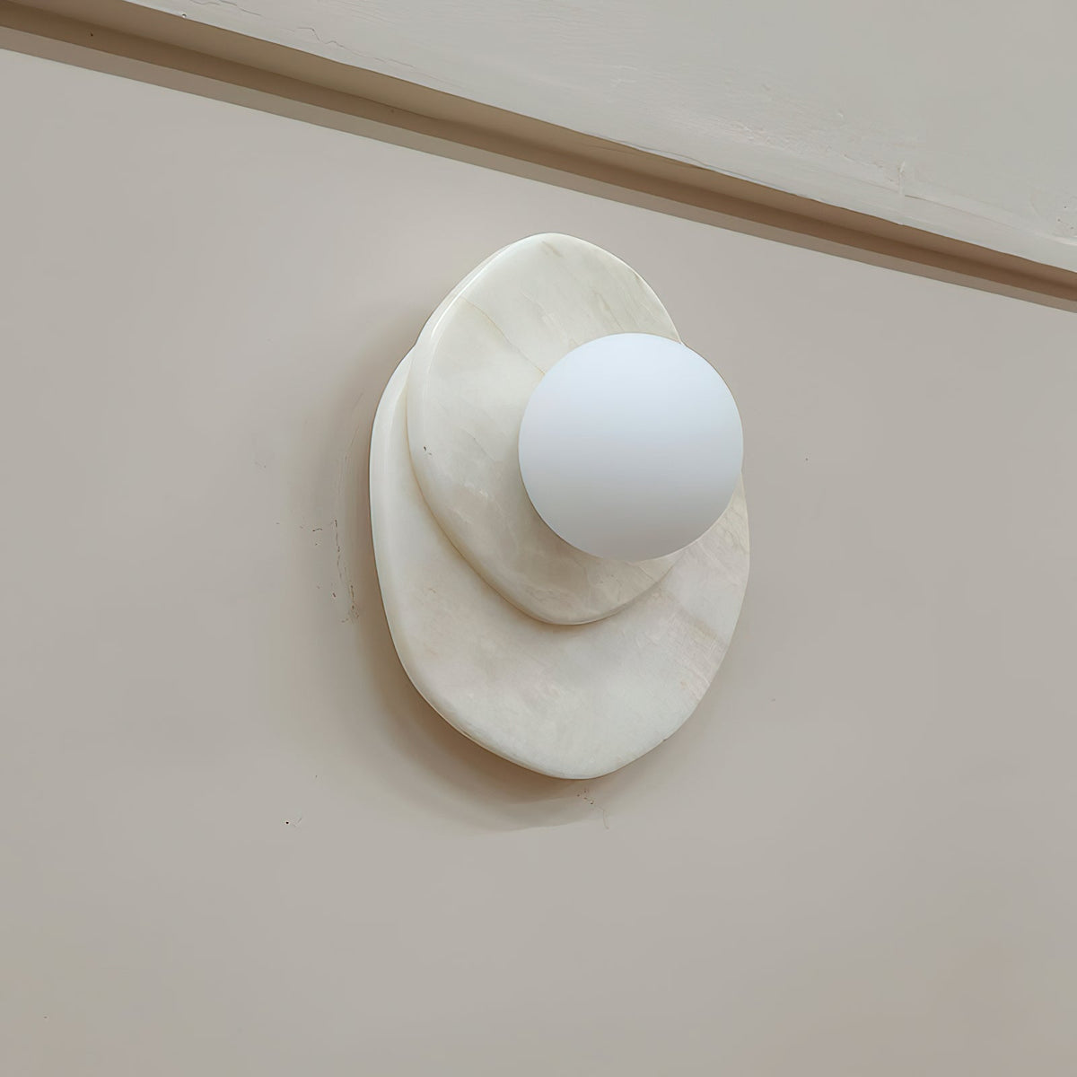 A side view of the Clérachic wall light shows how far its stone discs and glass globe project from the wall surface.