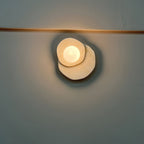 Glowing against a dark teal wall beneath a brass rail, this Clérachic wall light's globe stands out in a moody night shot.