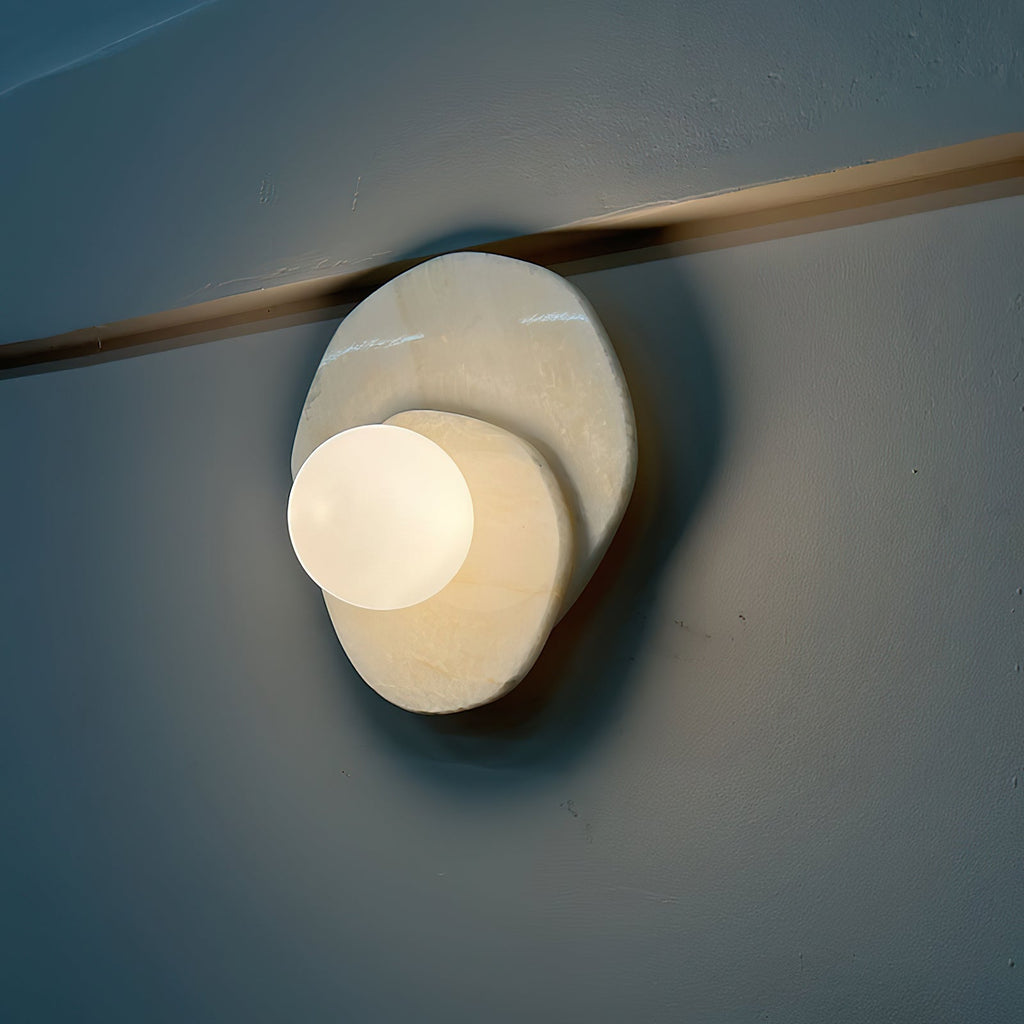 On a deep blue wall under the same brass rail, the Clérachic wall light repeats its warm glow in a different room tone.