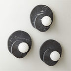 Three Clérachic wall lights in black marble, sized small to large, are grouped together to show the range side by side.