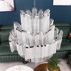 Close beside a green leather sofa, this lit silver Clérachic chandelier shows its full tiered scale.