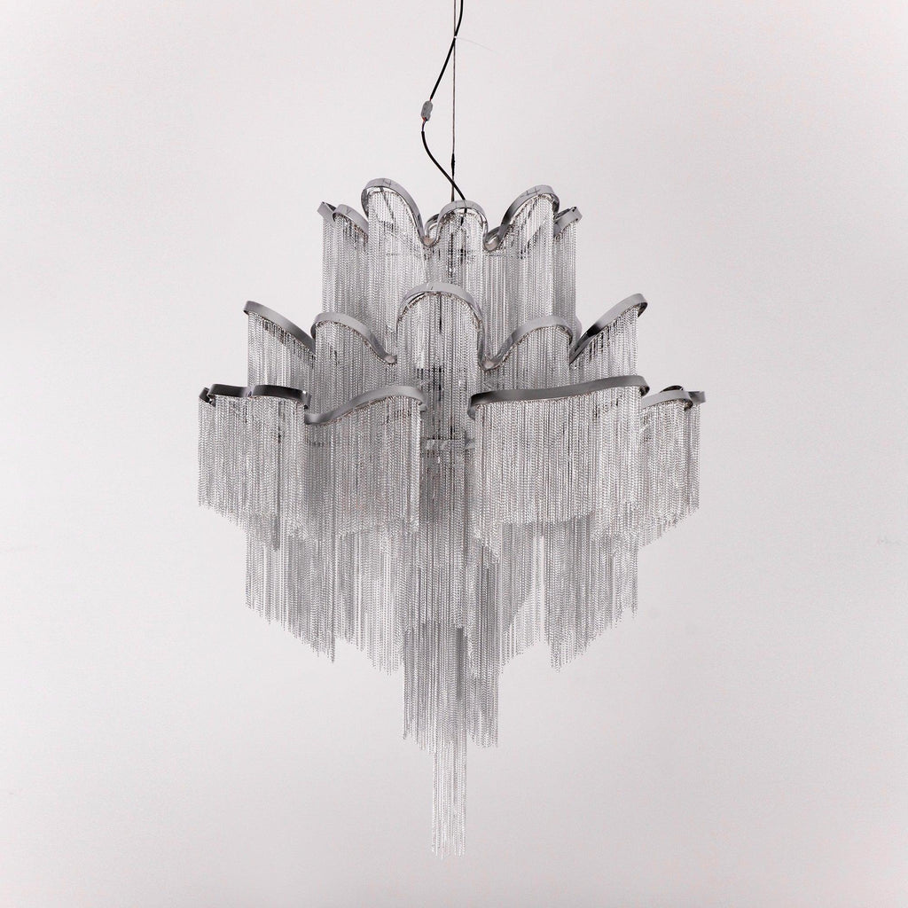 Unlit against a white backdrop, this silver Clérachic chandelier's chain fringe hangs in full view.