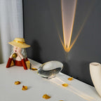Clear crystal table lamp glowing warmly on a neutral surface