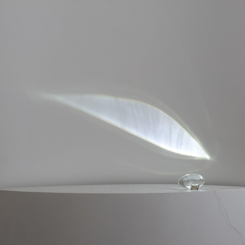 Crystal oval table lamp glowing on chrome base in a styled corner