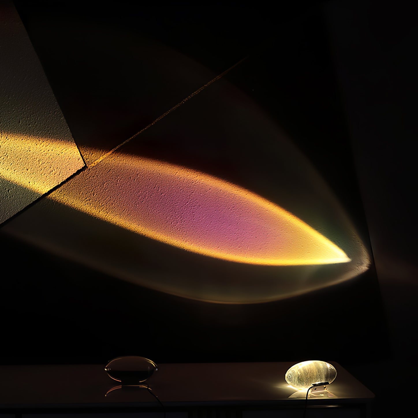 Clear crystal oval table lamp lit softly on a bedside surface