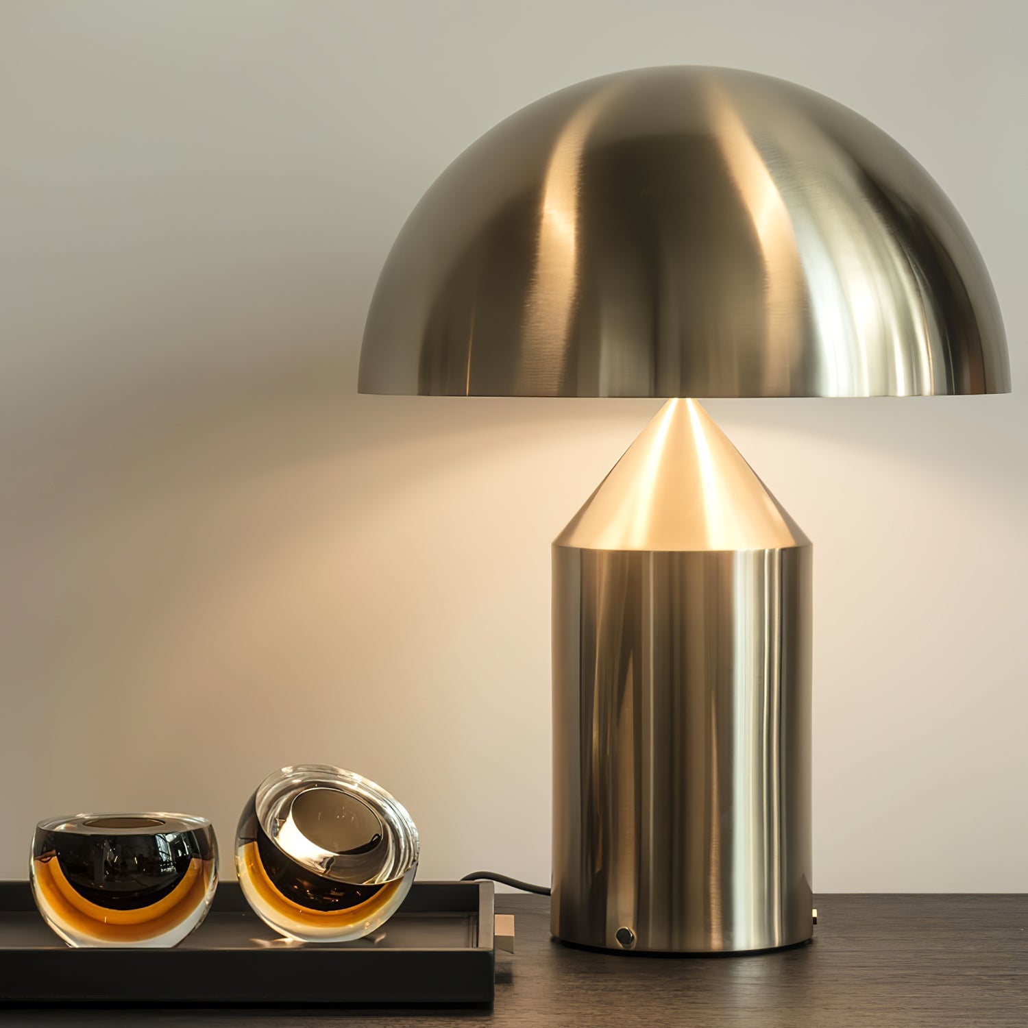 Sculptural metal table lamp lit on a bedside surface