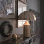 Sculptural metal table lamp on a console with decor