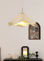 Above a styled console set with a mirror and ceramic vases, this beige Clérachic pendant light glows softly.