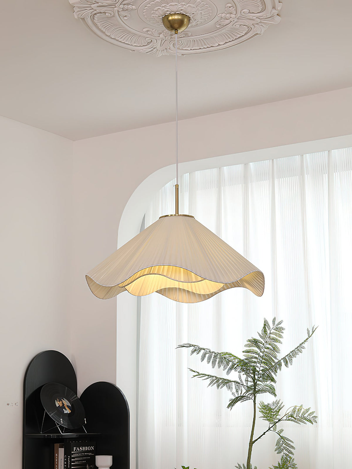 Beneath an ornate ceiling medallion, this beige Clérachic pendant light glows in front of a sheer curtain.