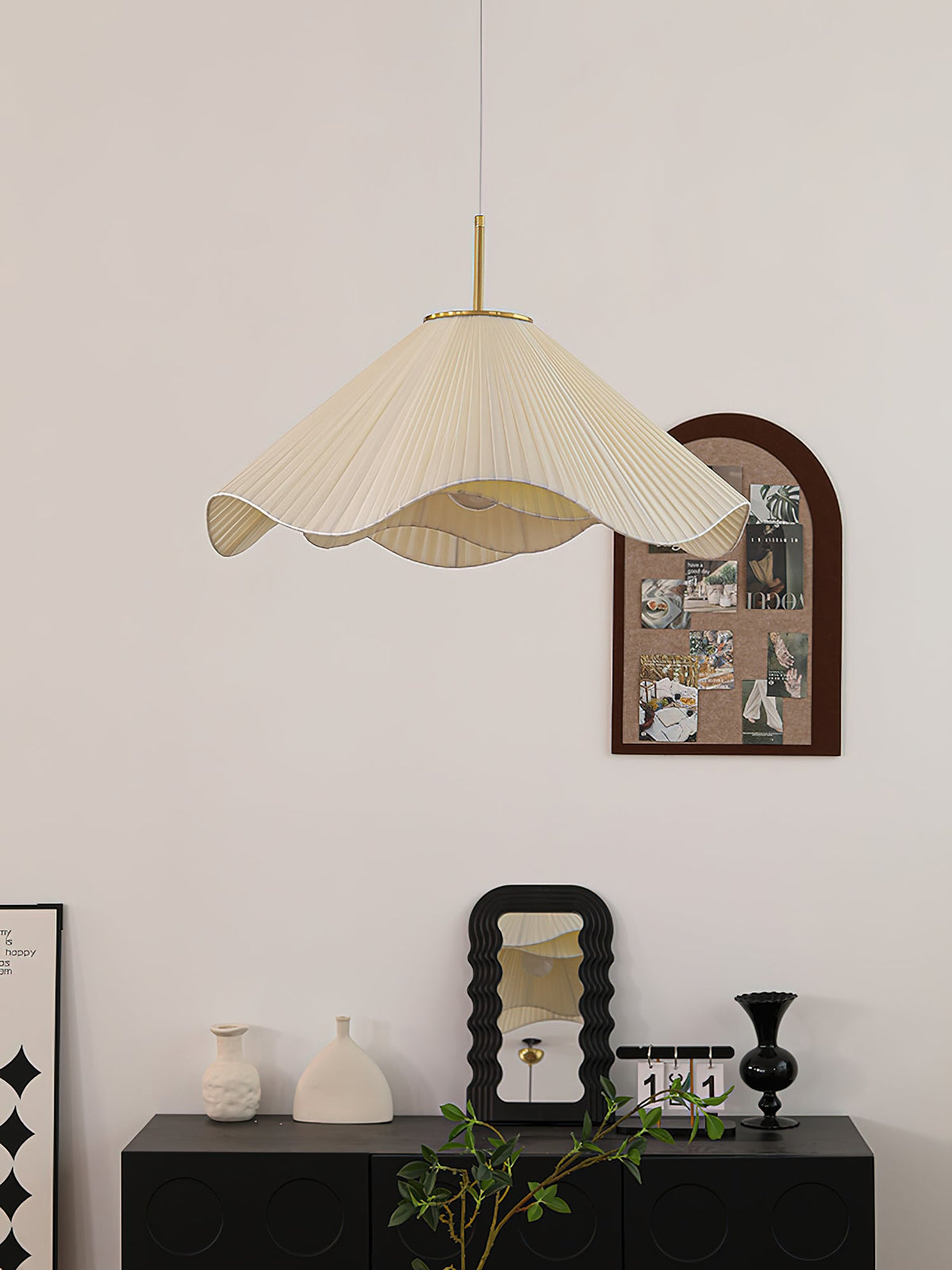 Beside a dark console dressed with a mirror and small vases, this beige Clérachic pendant light glows softly.