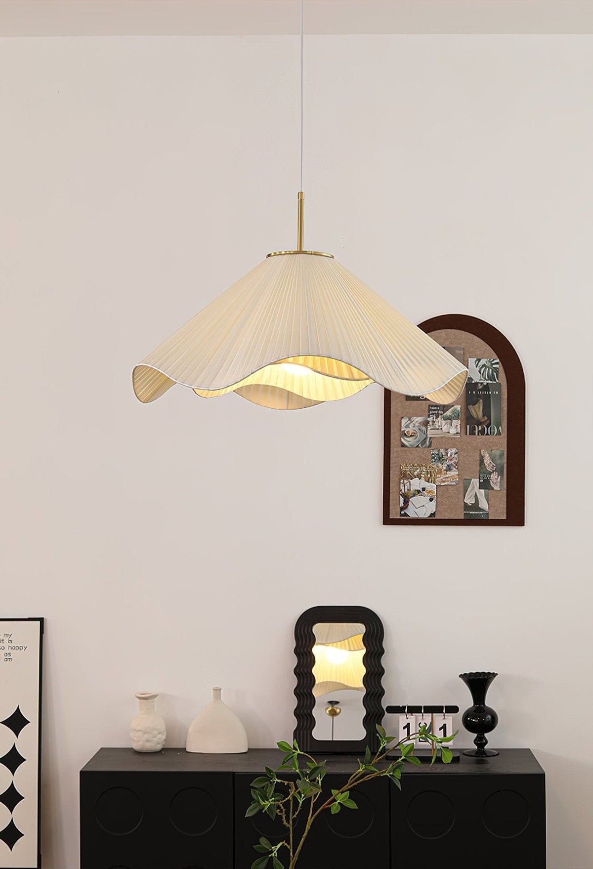 Above a dark console styled with small white vases, this beige Clérachic pendant light glows near a round mirror.