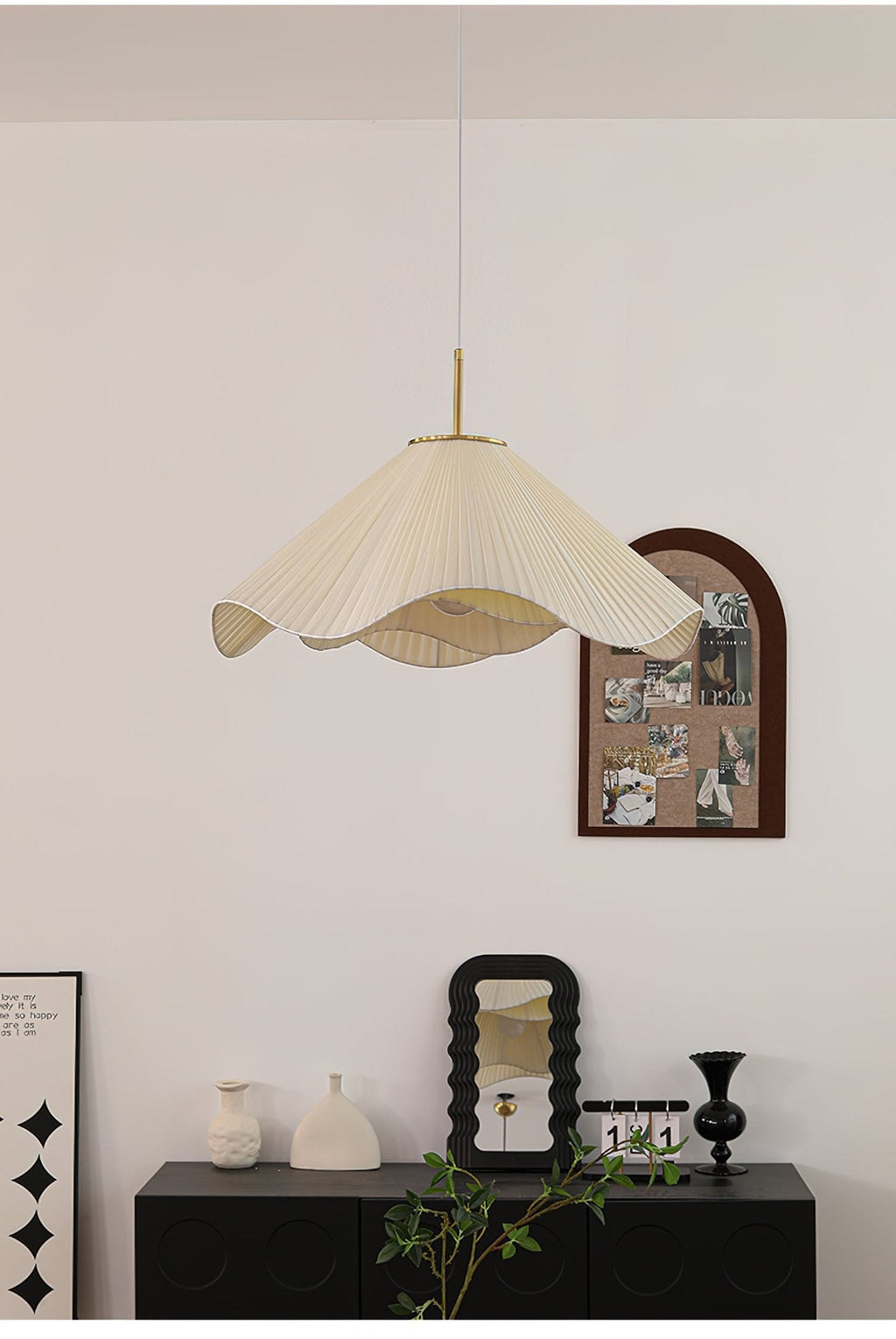 Above a dark console set with a small mirror and ceramic vases, this beige Clérachic pendant light glows warmly.