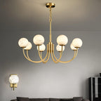 Clérachic lit against a grey wall beside a matching alabaster wall sconce mounted lower left
