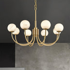 Clérachic three-quarter view of the lit chandelier against a dark grey concrete wall