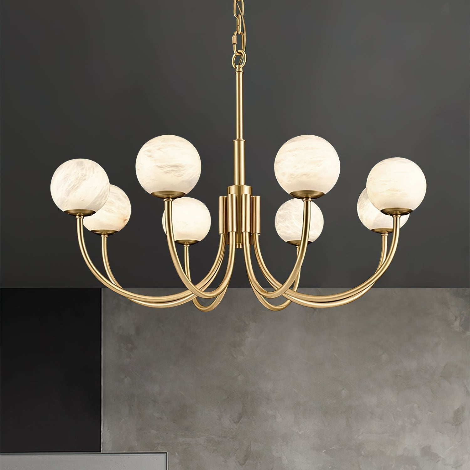 Clérachic three-quarter view of the lit chandelier against a dark grey concrete wall