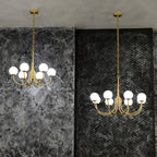 Two Clérachic of the chandeliers hung at different chain lengths against textured grey and black walls