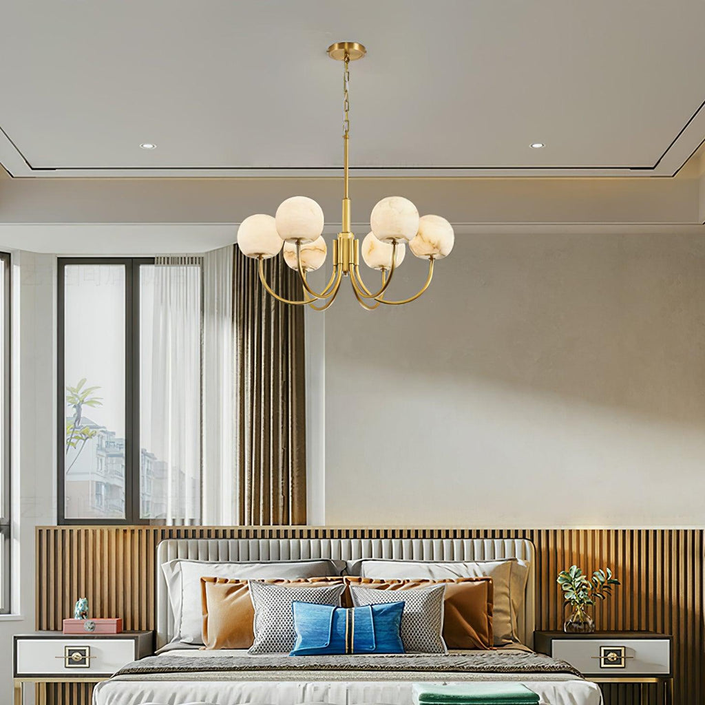 Clérachic hung above a bed with a fluted wood headboard, the alabaster globes reading soft cream in daylight