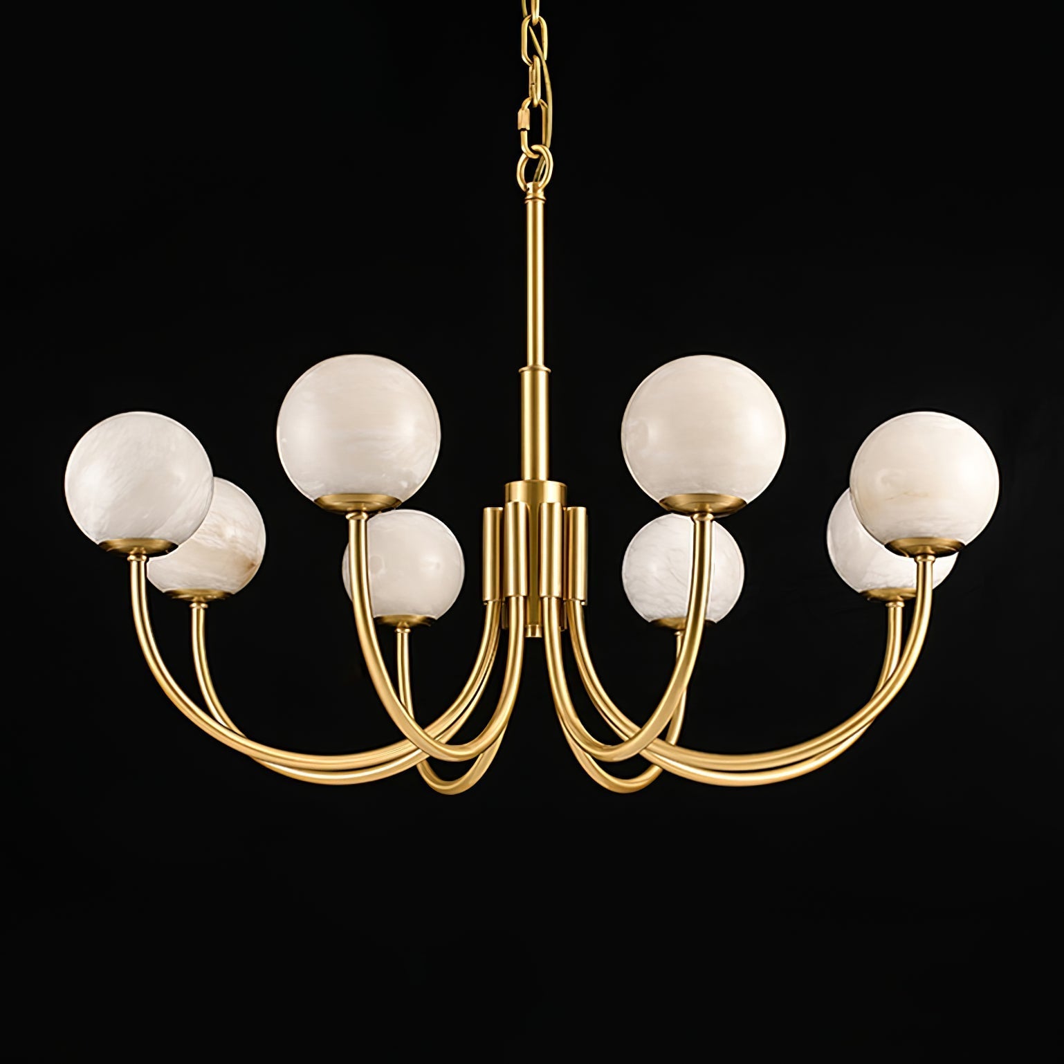Clérachic lit on a black backdrop with a long chain drop, brass arms curving out beneath the globes