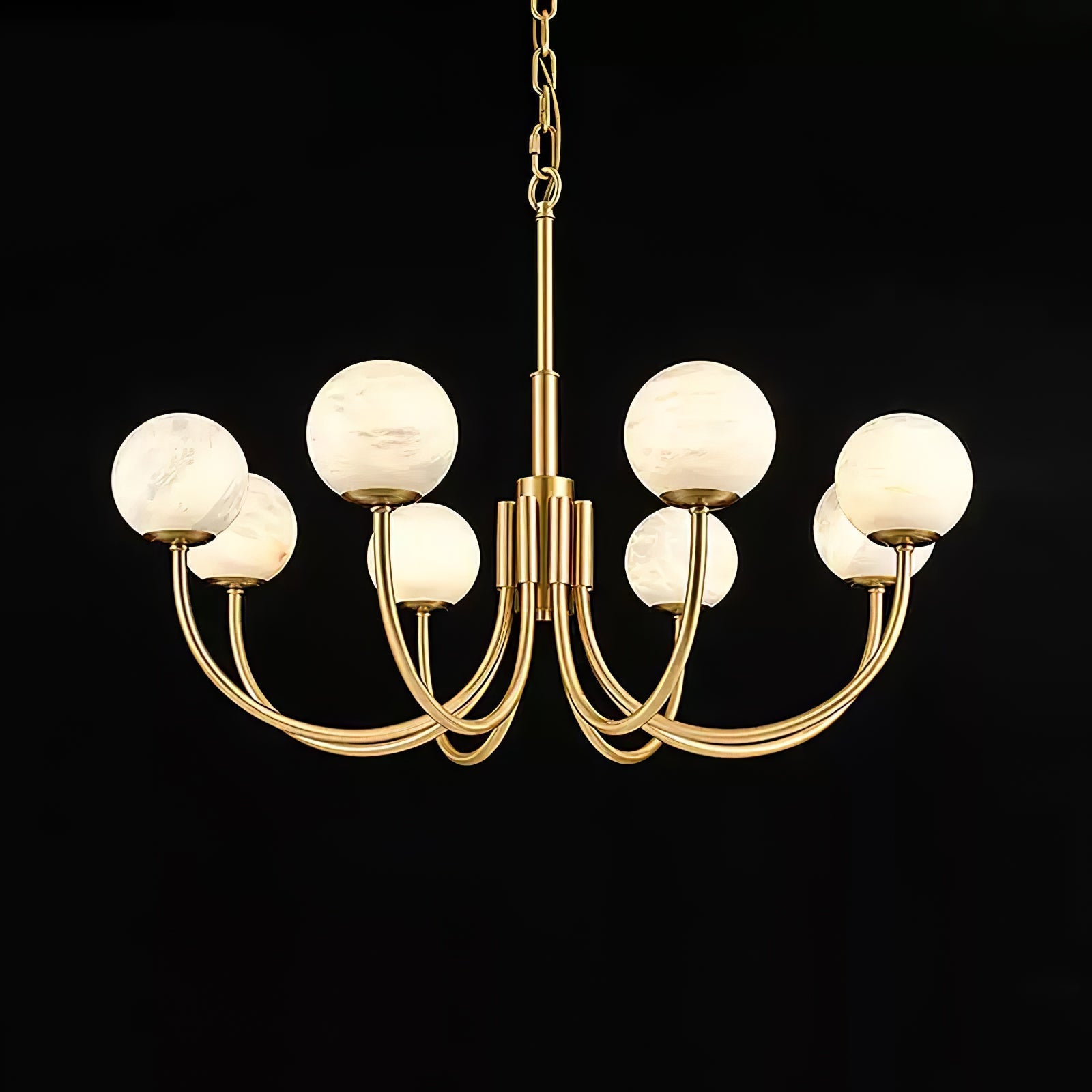 Clérachic lit on black in a wider frame, the warm globes contrasting with the polished brass arms