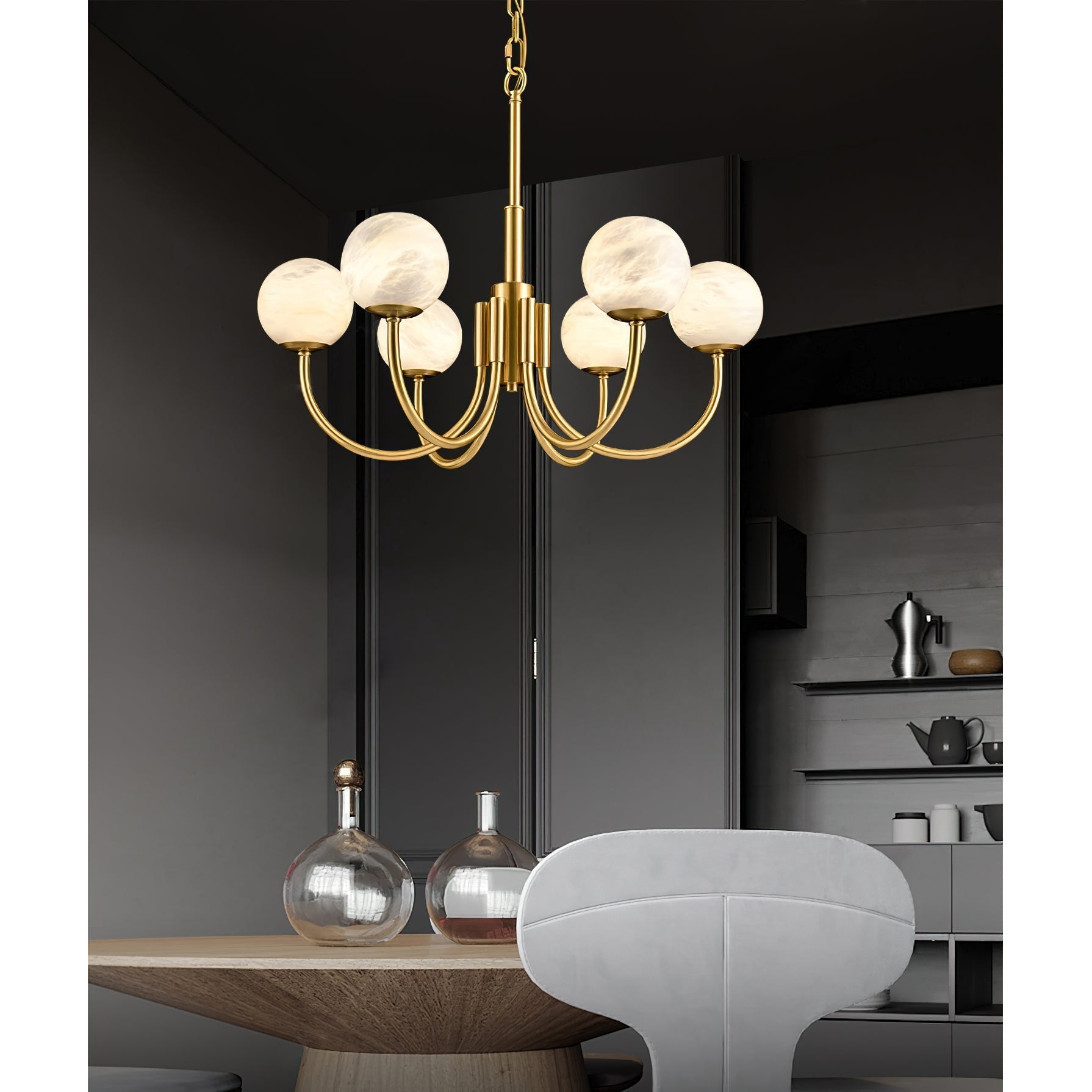 Clérachic warm globes lit above a round wooden dining table set with glass decanters in a charcoal room