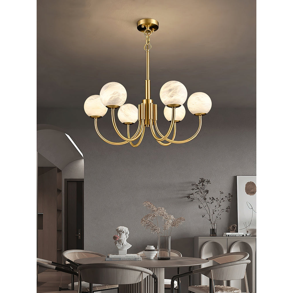 Clérachic lit above a round dining table and chairs, with an arched doorway and sideboard behind