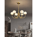 Clérachic lit above a round dining table and chairs, with an arched doorway and sideboard behind